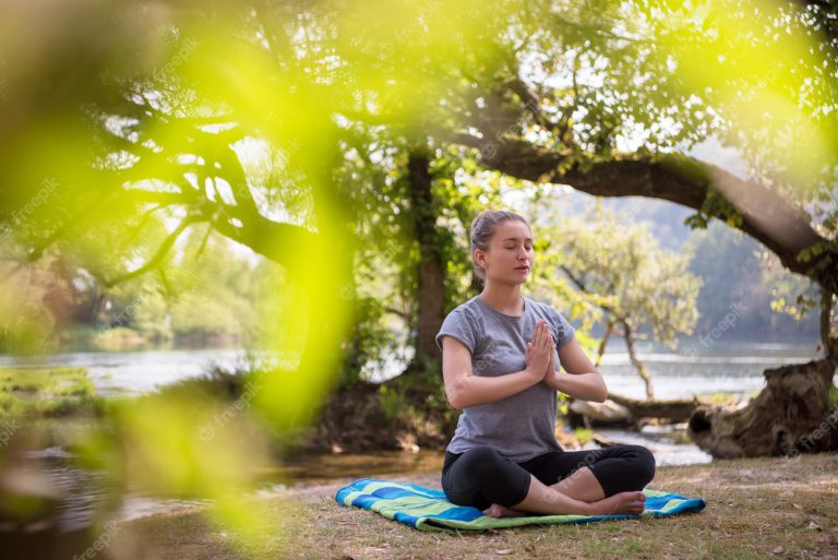 Healthy woman relaxing while meditating and doing yoga exercise i